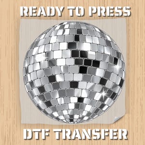 May include: A silver disco ball graphic with a grid of reflective square mirrors. The text READY TO PRESS is printed in white above the disco ball, and the text DTF TRANSFER is printed in white below the disco ball on a light gray square.