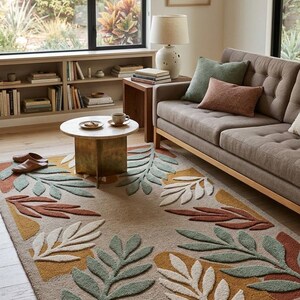 May include: A beige rug featuring a leaf pattern in green, white, yellow, and rust. The rug is in a living room with a sofa, coffee table, and natural light. The rug's dimensions are in centimetres.