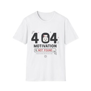 Può includere: Una t-shirt bianca a maniche corte con una grafica che riporta il testo 404 MOTIVATION NOT FOUND. Il design include l'icona di una batteria scarica con una faccia triste, una barra di ricerca e il testo PLEASE RECHARGE AND TRY AGAIN LATER.