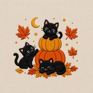 Op de afbeelding: Een borduurontwerp met drie zwarte kittens met grote ogen. Eén kitten zit bovenop een stapel van twee oranje pompoenen, een ander staat ernaast en de derde ligt op oranje herfstbladeren. Een gele halve maan en sterren omringen de figuren.