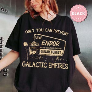 May include: A white ceramic mug with a black handle and the text "But First, Coffee" in a bold, black font. The mug is set against a blurred background, highlighting its clean design.