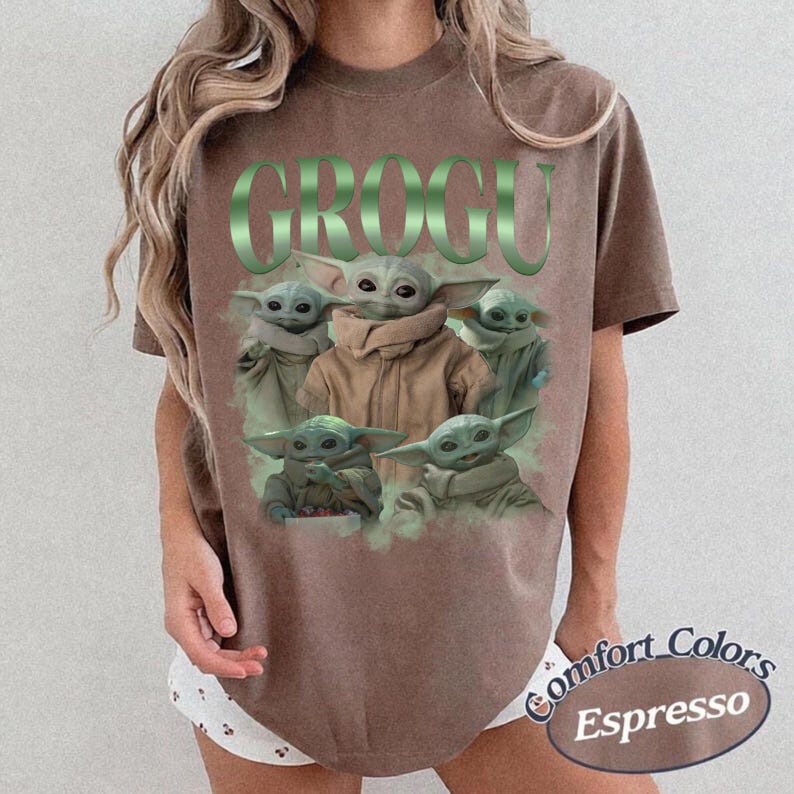 Op de afbeelding: Espresso-kleurig T-shirt met het woord "GROGU" in groen, met meerdere Grogu-personages. Het shirt is van het merk Comfort Colors.
