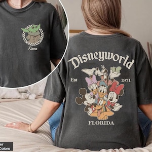 Op de afbeelding: Een witte keramische mok met een zwart handvat en de tekst "But First, Coffee" in een vetgedrukte, zwarte letter. De mok staat op een houten oppervlak. De mok lijkt ongeveer 355 ml te bevatten.