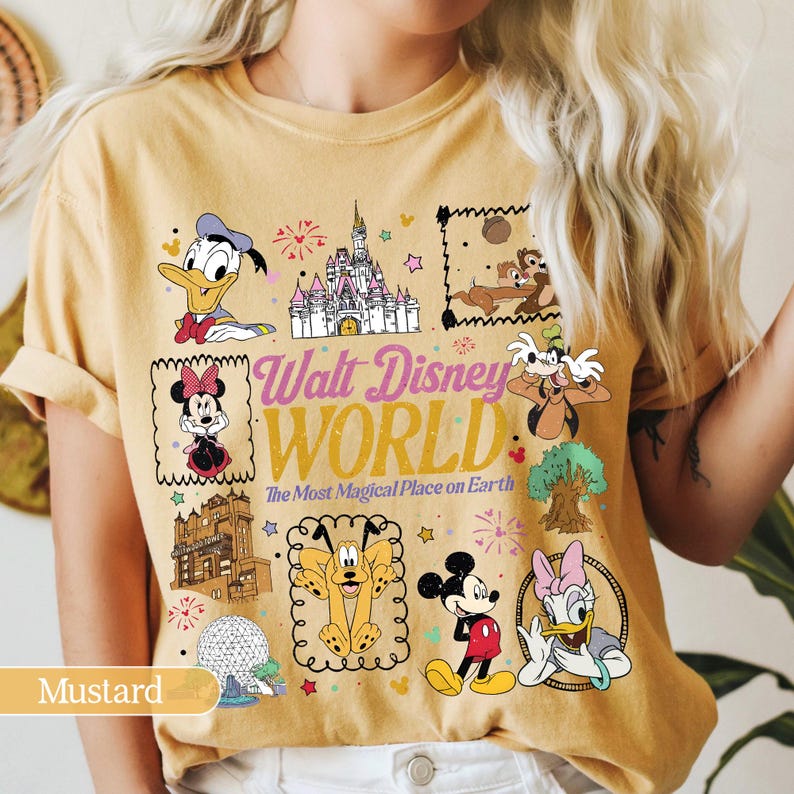 May include: Mustard-colored t-shirt featuring various Disney characters and the text "Walt Disney World". The design includes Donald Duck, Minnie Mouse, Mickey Mouse, and other characters, along with a castle and fireworks.