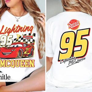 May include: White t-shirt with a graphic of Lightning McQueen from the Cars film. The front shows "Lightning 95 McQueen" with a red race car. The back has a large yellow "95" and "Lightning McQueen" text.