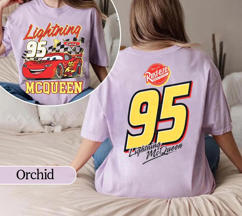 May include: Orchid-coloured t-shirt featuring Lightning McQueen from the Cars movie. The front graphic shows McQueen with the text "Lightning 95 McQueen". The back displays a large "95" and "Lightning McQueen" text.
