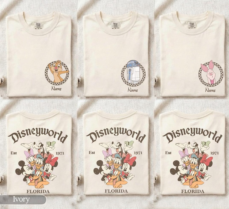 Op de afbeelding: Ivoor kleurige T-shirts met Disney-personage afbeeldingen. Ontwerpen omvatten Chip, R2-D2 en Winnie de Poeh, elk in een cirkelvormig kader met het woord "Name" eronder. Andere shirts tonen een Disney World afbeelding.