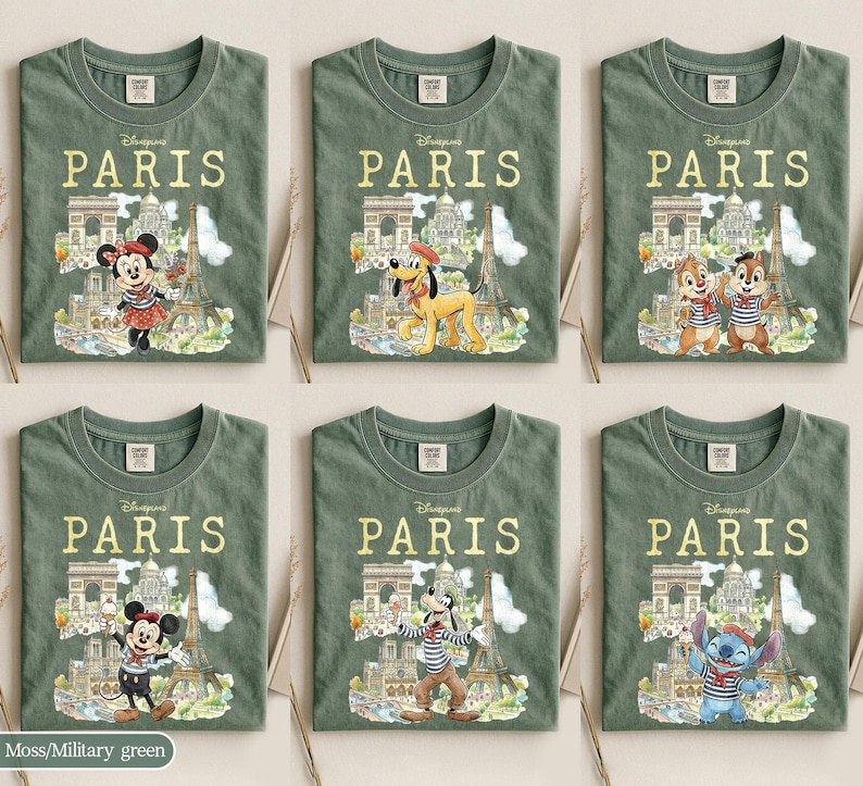 K&ouml;nnte beinhalten: Sechs olivgr&uuml;ne T-Shirts mit dem Wort "PARIS" in goldener Schrift. Jedes Shirt zeigt eine andere Disney-Figur vor Pariser Wahrzeichen wie dem Eiffelturm und dem Arc de Triomphe. Figuren sind Minnie Maus, Pluto, Chip und Chap, Micky Maus, Goofy und Stitch.