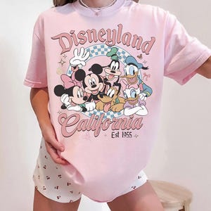 May include: A white ceramic mug with a black handle and the text "But First, Coffee" in a black, bold font. The mug is on a white surface.