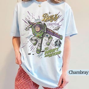 Puede incluir: Camiseta azul claro con un dise&ntilde;o de Buzz Lightyear de Toy Story. El dise&ntilde;o incluye el texto "Buzz Lightyear" y "To Infinity and Beyond". La camiseta es de color azul claro.