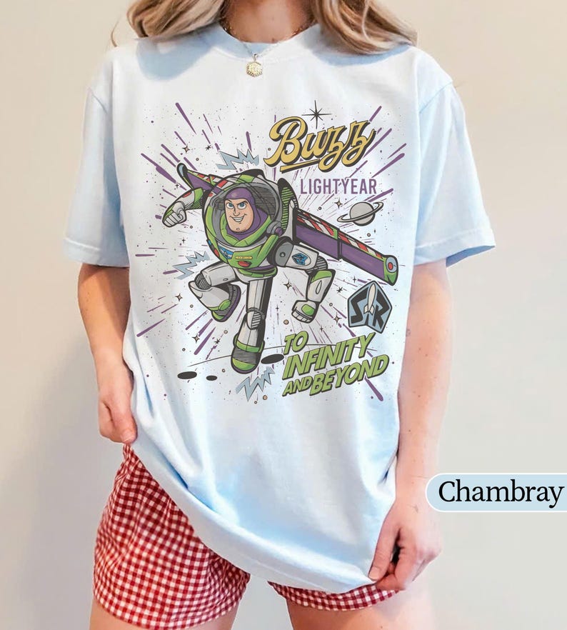 Puede incluir: Camiseta azul claro con un dise&ntilde;o de Buzz Lightyear de Toy Story. El dise&ntilde;o incluye el texto "Buzz Lightyear" y "To Infinity and Beyond". La camiseta es de color azul claro.
