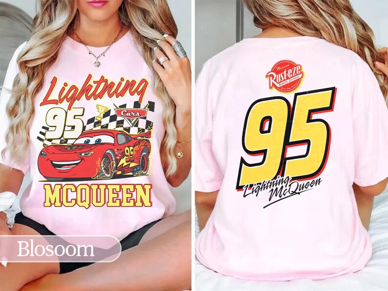May include: Pale pink t-shirt with a graphic of Lightning McQueen from the Cars film. The front design includes the text "Lightning 95 McQueen" with a checkered flag. The back of the shirt displays a large "95" and "Lightning McQueen" text.