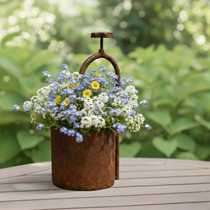 May include: A weathered metal planter, filled with a colourful arrangement of blue, white, and yellow flowers. The planter features a handle and a screw-like top, giving it a vintage feel. The flowers are in full bloom, creating a cheerful display.