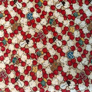 May include: A festive fabric pattern featuring a repeating design of red berries, popcorn, and Christmas-themed cookies. The cookies include gingerbread men, snowmen, stars, and decorated circles, all set against a beige background.