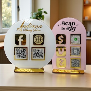 May include: Two decorative signs for a beauty salon. One is white with gold accents, the text "Indiana Beauty Salon", and social media icons. The other is pink with gold accents and the text "Scan to Pay" with payment icons and QR codes.