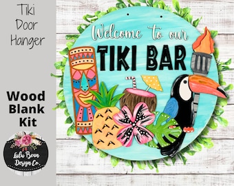 May include: A round wooden door hanger with a blue background and the text "Welcome to our Tiki Bar". The hanger is decorated with a tiki idol, a pineapple, a flower, a toucan, and a coconut drink with an umbrella.