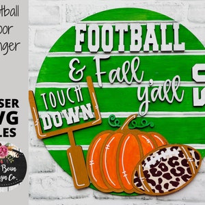 May include: A green and white round wooden sign with the text "FOOTBALL & Fall y'all" and the number "50". The sign also features a football, a pumpkin, and a football goal post.