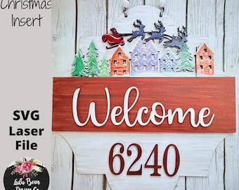 Puede incluir: Un letrero de bienvenida navideño de madera en rojo y blanco. El letrero presenta una parte superior decorativa con un trineo y renos, casas y árboles. Se muestra la palabra "Welcome" y el número "6240". Para la decoración del hogar.