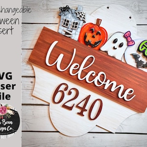 Könnte beinhalten: Ein weißes und braunes Holzschild mit einem Willkommensschild und der Nummer 6240. Das Schild ist mit Halloween-Ausschnitten verziert, darunter ein Geist, ein Kürbis, ein Haus und eine Fledermaus.