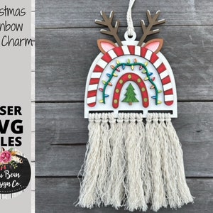 May include: A white wooden Christmas rainbow car charm with red and white candy cane stripes, a green Christmas tree, and white lights. The charm has a white tassel hanging from the bottom.