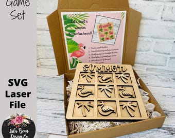 May include: A wooden tropical-themed tic-tac-toe game set in a cardboard box. The game board features cut-out palm trees and flamingos. The box includes paint and instructions. The text "Tropical Game Set" is visible.