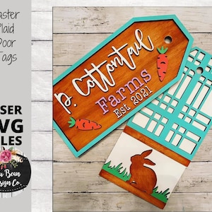 May include: A wooden sign with the text "P. Cottontail Farms Est 2021" in white script. The sign is painted brown with a turquoise border and features a carrot graphic. A second sign with a plaid pattern is also visible.
