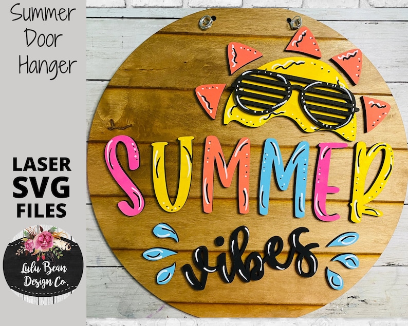 May include: A wooden round door hanger with the words "Summer Vibes" in black lettering. The word "Summer" is in colorful letters with a yellow sun with sunglasses above it.