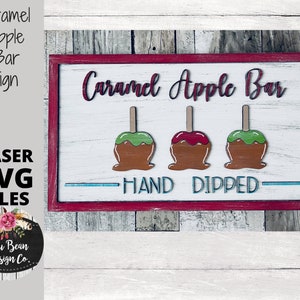May include: Wooden sign with a red frame, featuring the words "Caramel Apple Bar" and three caramel apples. The sign also includes the text "Hand Dipped" and "Laser SVG Files."