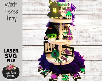 May include: A three-tiered tray decorated for Halloween with a witch hat, a house with a light, a witch silhouette, a cauldron, a skull and crossbones, and a sign that says "Witch Have My Spools".