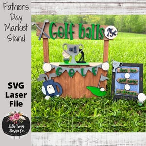 May include: A wooden golf ball stand with a sign that says "Golf balls 25c". There is a golf trophy, golf clubs, and golf balls on the stand. The stand is on a green grassy surface.