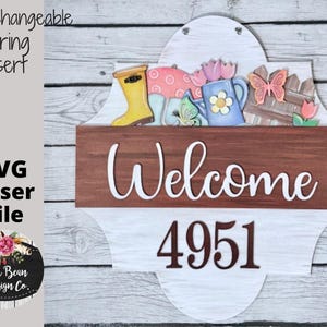May include: Interchangeable spring insert SVG laser file for a welcome sign with a brown wooden background and a white welcome sign with the number 4951. The sign features a decorative top with a butterfly, flowers, and a watering can.