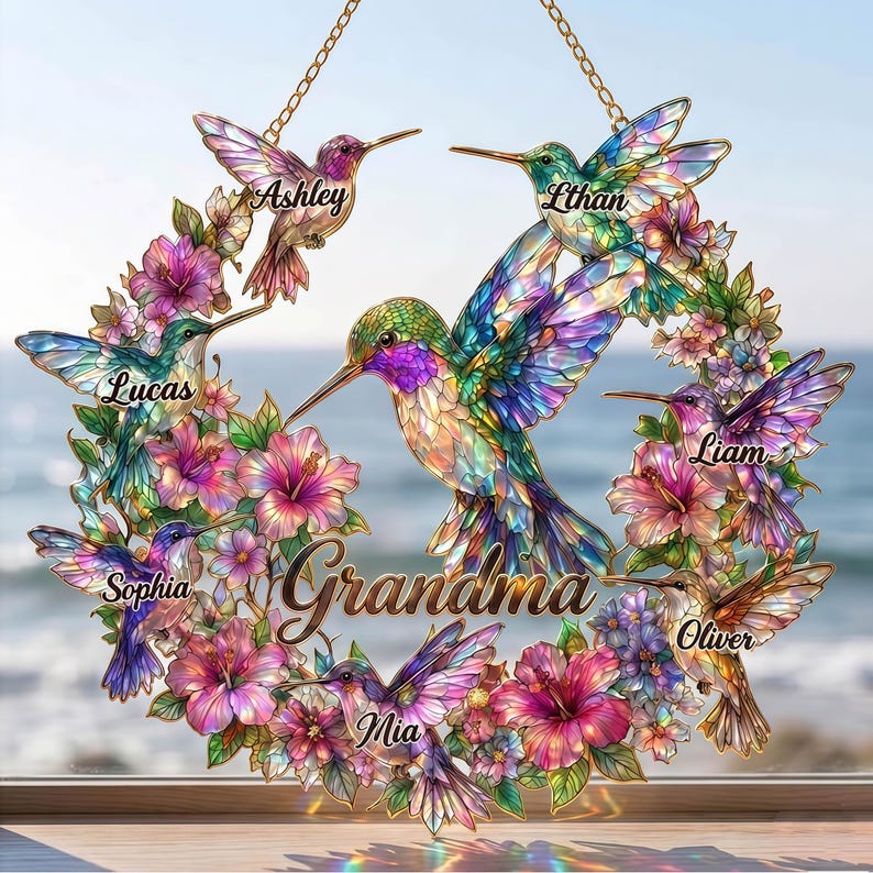 May include: A decorative hummingbird wreath with the word "Grandma" in the center. The wreath features colorful hummingbirds and flowers, with names like "Ashley", "Ethan", "Lucas", "Liam", "Mia", "Oliver", and "Sophia" displayed.