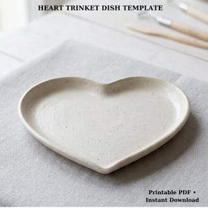 Puede incluir: Un juego de tres tazas de cerámica con un acabado moteado y mate. Las tazas son de color crema, gris claro y gris oscuro. Cada taza tiene un diseño simple y minimalista.