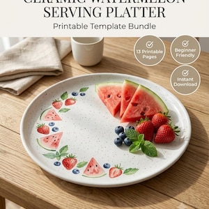 May include: A white ceramic serving platter featuring a speckled finish and a decorative border of painted watermelon slices, strawberries, blueberries, and green leaves. The platter is displayed with fresh fruit slices on top.