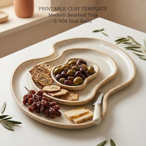 Könnte beinhalten: Ein Set aus drei gesprenkelten Keramik-Servierplatten in Muscheldesign. Die Platten sind mit Oliven, Crackern, Trauben und Käse gefüllt. Der Text auf dem Bild lautet: "PRINTABLE CLAY TEMPLATE Modern Seashell Tray 6 MM Slab Build."