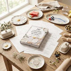 May include: A collection of ceramic pottery items including two daisy-shaped dishes, two speckled butter dishes, a fish-patterned oval plate, and a book titled 20 CERAMIC TEMPLATE BUNDLE Printable Pottery Templates, arranged with wooden rolling pins.