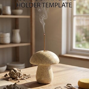 May include: A speckled beige ceramic mushroom incense holder with a burning incense stick emitting smoke. The text MUSHROOM INCENSE HOLDER TEMPLATE is visible above the object. Sculpting tools and clay pieces are arranged on the surface.