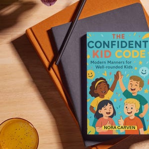Peut inclure: Un livre intitulé "The Confident Kid Code" avec une couverture colorée représentant des illustrations d'enfants. Le livre est posé sur une pile de cahiers et un crayon. Un verre de liquide jaune est au premier plan.
