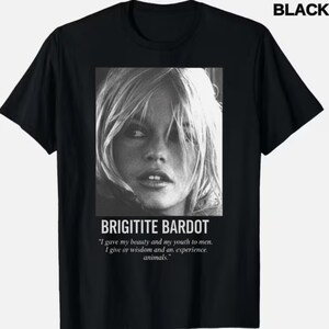 May include: Black t-shirt featuring a black and white portrait of Brigitte Bardot. The text "BRIGITITE BARDOT" is below the image, along with a quote about beauty, youth, wisdom, and animals. The word "BLACK" is in the upper right corner.