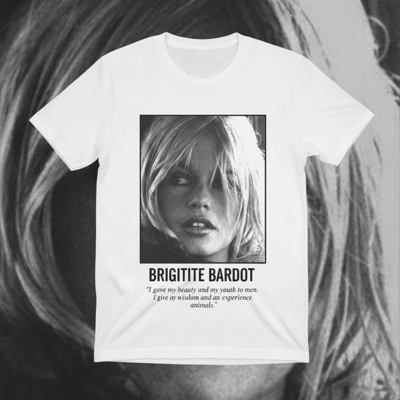 May include: White t-shirt featuring a black and white image of Brigitte Bardot. The image is in a square frame with the name "BRIGITITE BARDOT" below it, along with a quote about beauty, youth, wisdom, and animals.