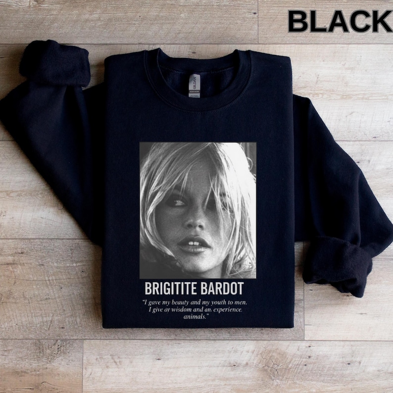 May include: Black crewneck sweatshirt featuring a black and white image of Brigitte Bardot. The image includes the text "BRIGITITE BARDOT" and a quote about beauty, youth, wisdom, and animals. The word "BLACK" is printed at the top.
