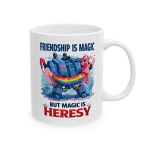 May include: White ceramic mug featuring a cartoon illustration. The design depicts a blue robot embracing a pink pony with a rainbow. The text reads "Friendship is Magic" above and "But Magic is Heresy" below the image.