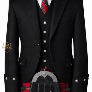 Puede incluir: Conjunto formal de chaqueta, chaleco y kilt negros. La chaqueta tiene botones y detalles en los puños plateados. Se ve una corbata a cuadros roja, verde y amarilla. El kilt es de cuadros rojos y negros. Un sporran plateado cuelga del kilt.