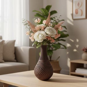 May include: A dark brown vase with a complex, open-work lattice pattern holds a bouquet of white roses, pale peach sweet peas, and feathery pink astilbe stems mixed with green eucalyptus leaves, creating a textured floral arrangement.