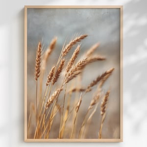 Könnte beinhalten: Gerahmter Kunstdruck mit Nahaufnahme von Weizenähren in Goldbraun vor einem weichen, gedämpften blauen Hintergrund. Der Druck ist in einem hellen Holzrahmen gefasst.