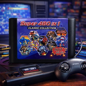 May include: A black video game cartridge labelled "Super 480 IN 1 CLASSIC COLLECTION" with various game graphics. The cartridge is on a 16-bit console with a connected controller. The controller has a start button and a directional pad.