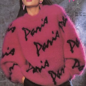 May include: A vibrant pink, fluffy sweater featuring the word "Paris" in black script. The sweater has long sleeves and a crew neck. The image also includes the text "Sunbeam" and "Paris" with an Eiffel Tower graphic. The sweater's bust size is 86-97 cm.