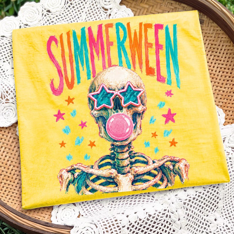 May include: Yellow canvas art featuring a skeleton wearing star-shaped sunglasses and blowing a bubblegum bubble. The word "SUMMERWEEN" is written in colorful letters above the skeleton. Pink, orange, and blue stars are scattered around the image.