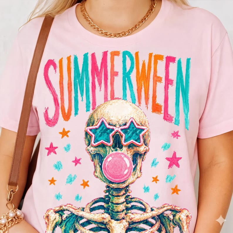 May include: Pink t-shirt with the word "SUMMERWEEN" in colorful letters. The graphic features a skeleton wearing star-shaped sunglasses and blowing a bubble. Pink, orange, teal, and gold stars are scattered around the skeleton.