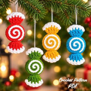 Może przedstawiać: Cztery szydełkowane ozdoby w kształcie cukierków wiszące na sznurkach. Każda ozdoba posiada centralny wzór spirali w kolorze czerwonym, zielonym, żółtym lub niebieskim, podkreślony białą włóczką na końcach i pośrodku. Widoczny jest tekst Crochet Pattern PDF.